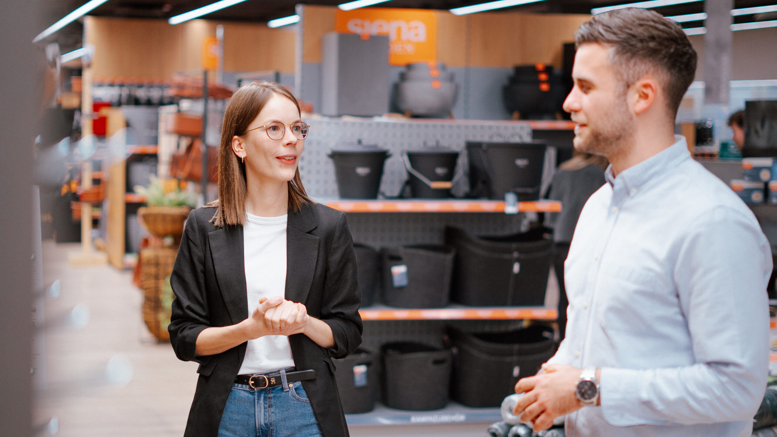 Eine Mitarbeiterin und ihr Kollege schauen sich an und unterhalten sich im Showroom von SIENA GARDEN.